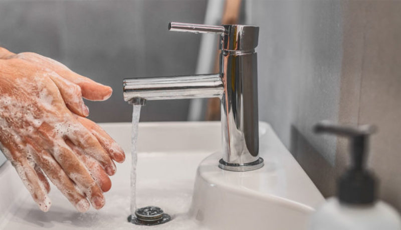Man washing hands to avoid germs and COVID-19.