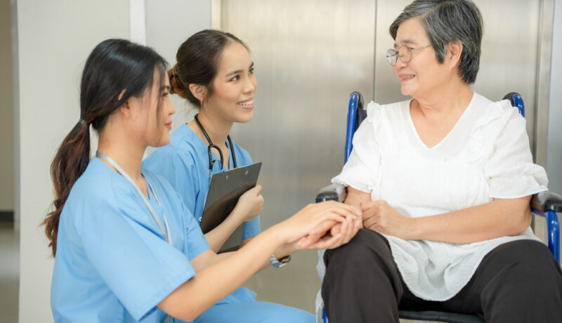 Two Nurses Smiling While Assisting an Elderly Woman in a Skilled Nursing Facility What is the Difference Between Skilled Nursing and Assisted Living