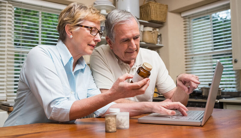A Senior Couple Using a Laptop to Look up Medicine Interactions at a Kitchen Table Drug Interactions in Older Adults